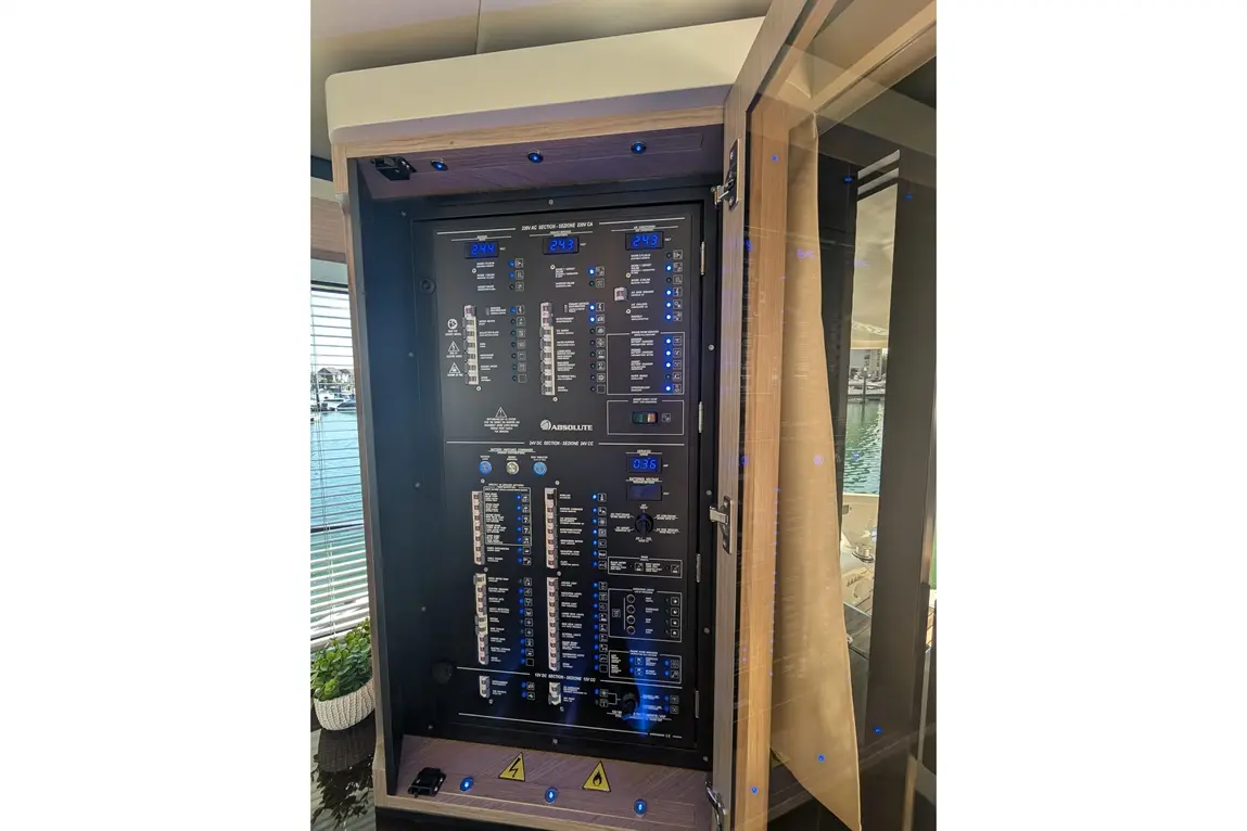 Control panel with multiple switches, indicators, and digital displays, showcasing settings in a marine setting.